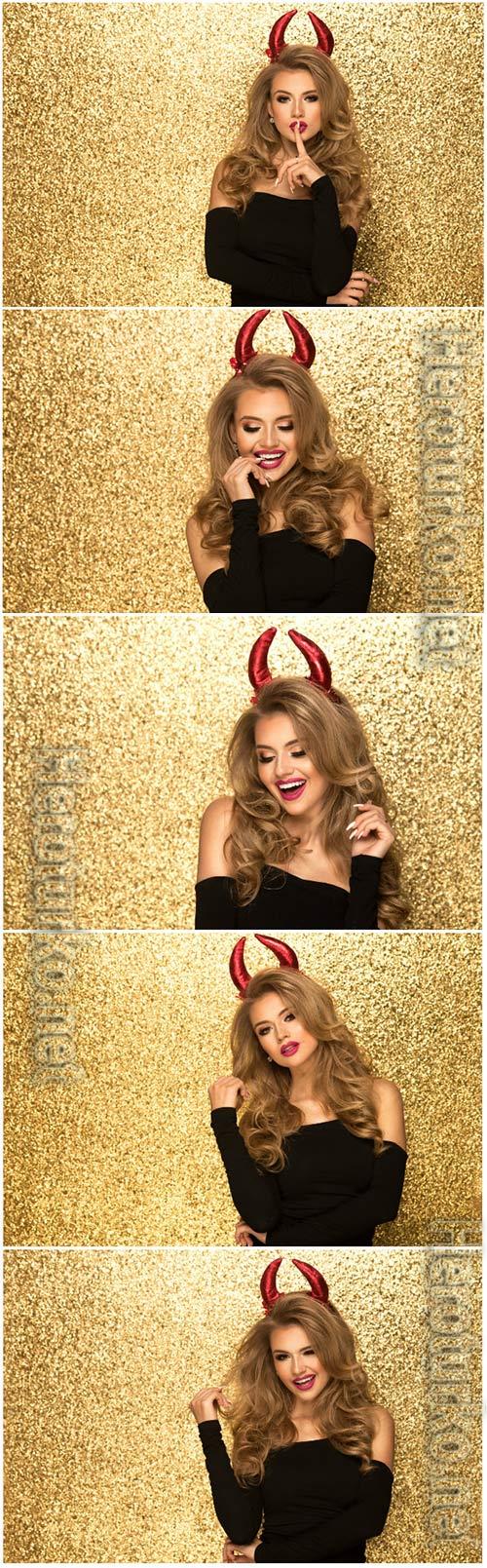 Girl with red horns on gold background stock photo Girl with red horns on gold background stock photo